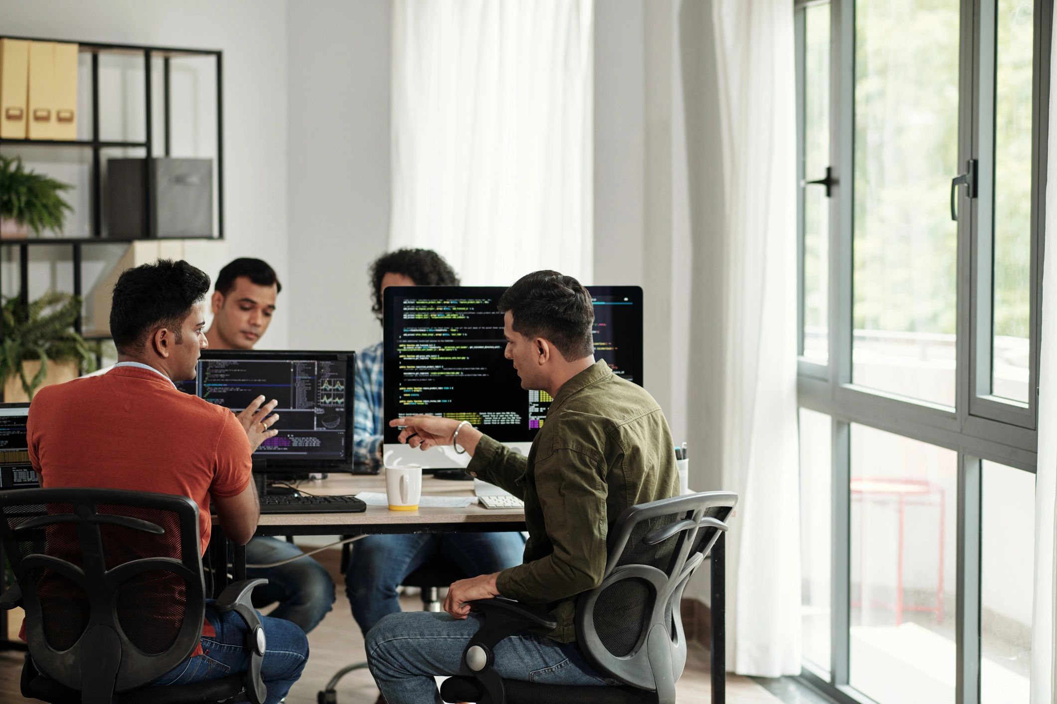 Developers discussing code on screens
