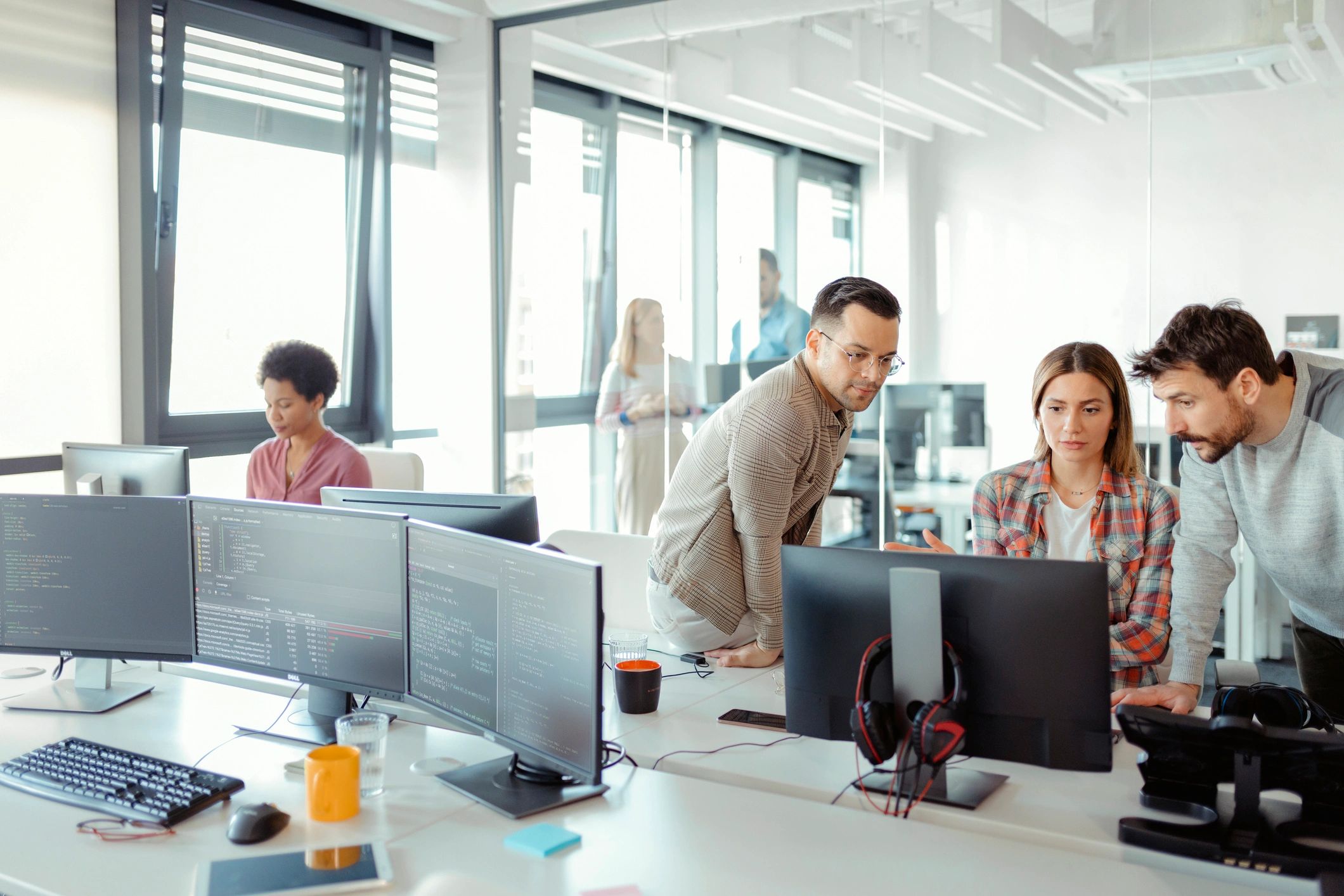 Team brainstorming around computers in an office