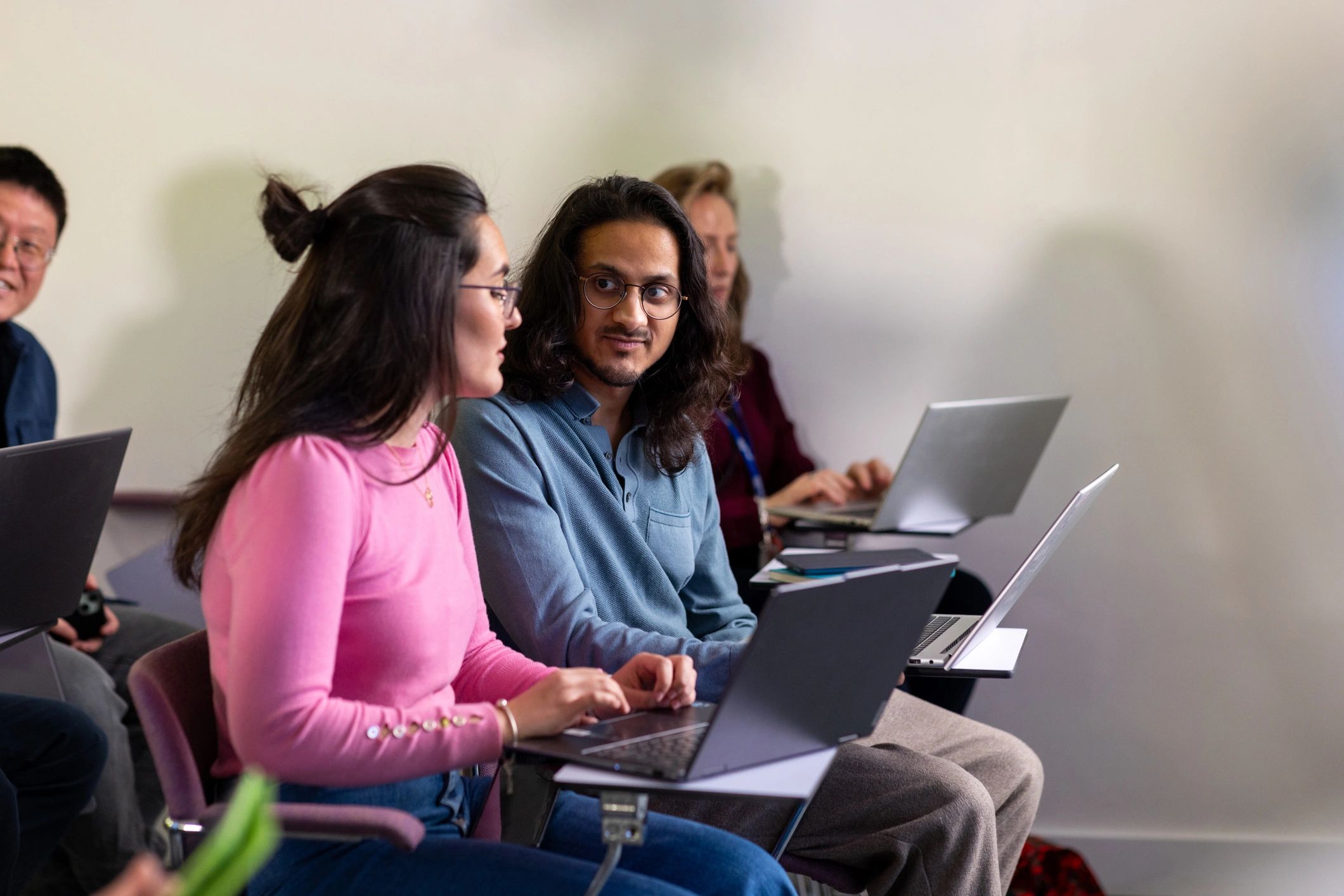 Group of professionals working on laptops during a seminar