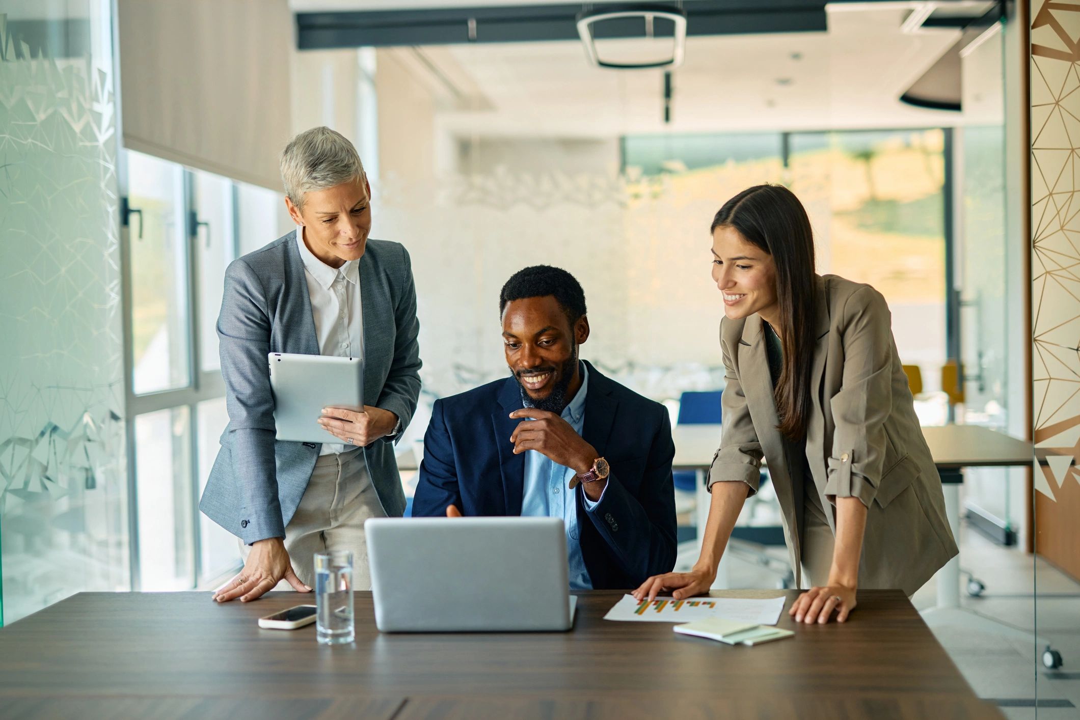 Business professionals collaborating using a laptop in a modern office